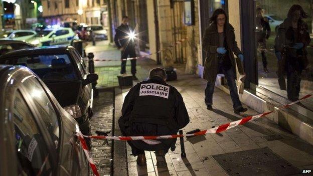 Policemen collect evidence on the site where a driver ploughed into a crowd injuring 11 people, Dijon, 21 December 2014