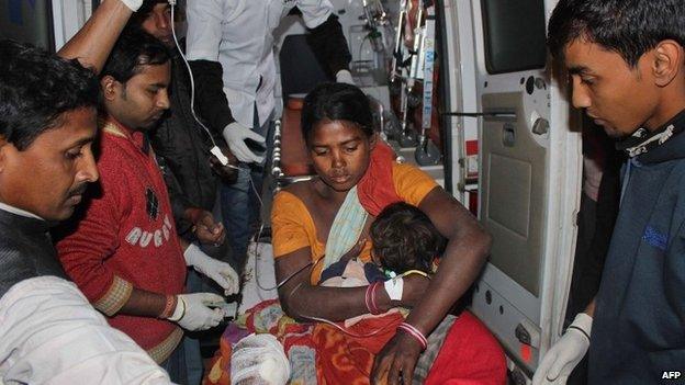 An injured women and her child arrive at a hospital in the Sonitpur district of Assam on December 23, 2014