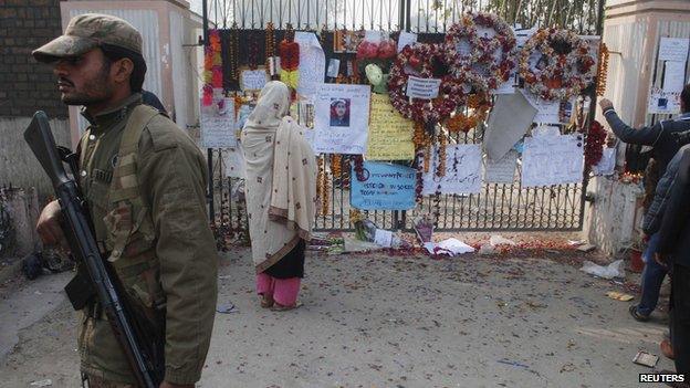 Soldier next to board for victims of Peshawar school attack