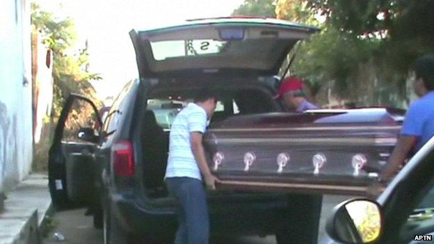 Father Gregorio Lopez's coffin is loaded into a hearse