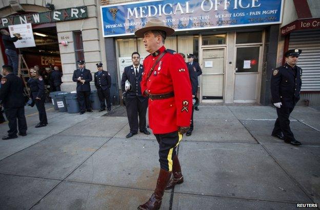 A member of the Royal Canadian Mounted Police stands with other policemen lining the streets near the Christ Tabernacle Church, 27 December