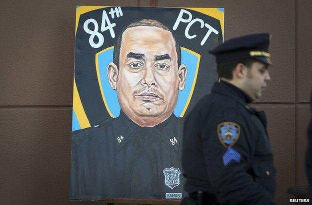 A police officer walks past a painting of NYPD officer Rafael Ramos in his funeral at Christ Tabernacle Church, 27 December