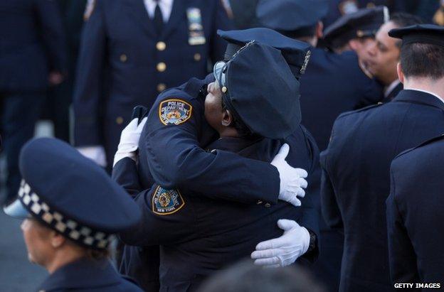 Police officers embrace at the funeral in New York, 27 December