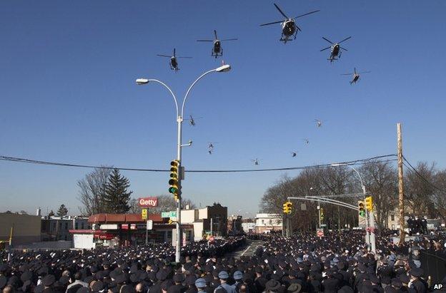 Police helicopters fly over the funeral procession in New York, 27 December