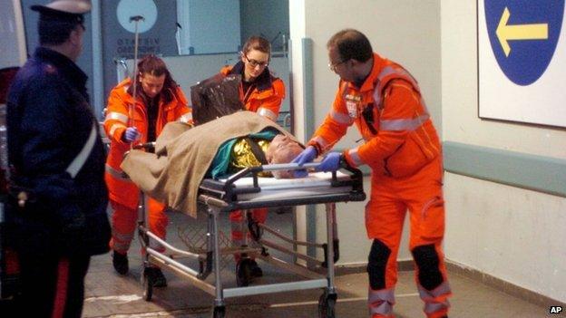 A man is carried by paramedics as passengers of the ferry that caught fire in the channel between Italy and Albania arrive at a Brindisi hospital, southern Italy, on 28 December 2014