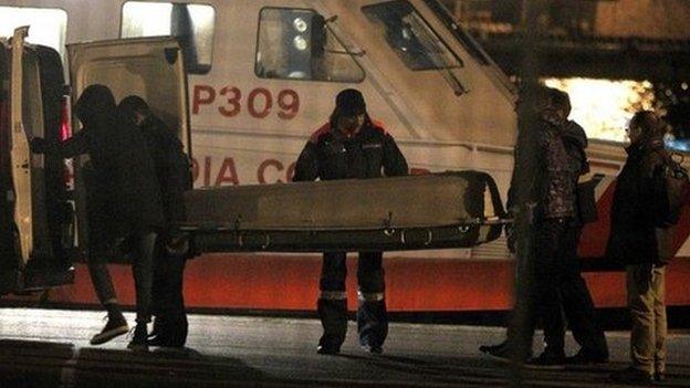 The Italian coast guard carries a body during an operation to rescue a stricken Italian ferry