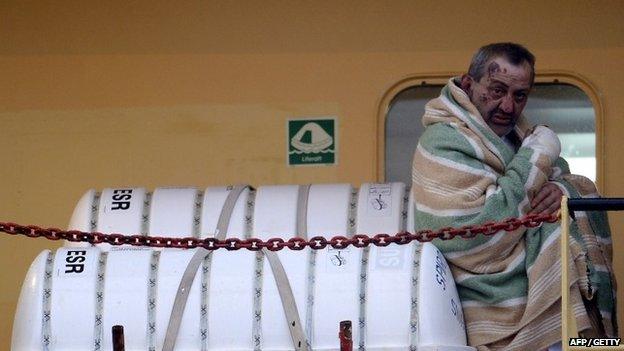 A wounded passenger among 49 survivors evacuated from the burning ferry "Norman Atlantic arrives aboard a cargo container ship to the harbour of Bari on December 29, 2014.