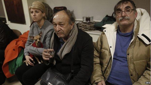 Rescued passengers of the Norman Atlantic ferry accident Nikos Baharis (centre) sits next to other passengers upon arrival at the airport of Elefsina, west of Athens (29 December 2014)