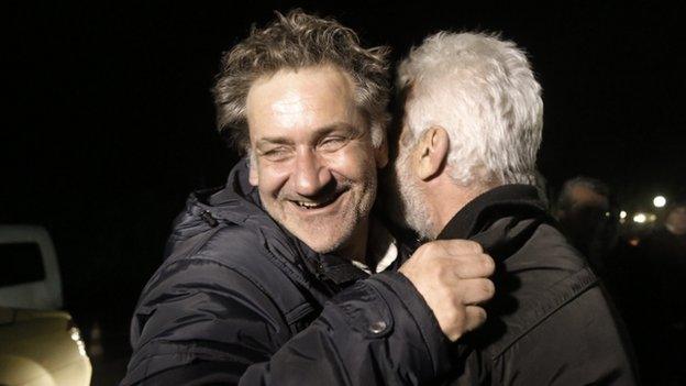 A rescued passenger (left) of the Norman Atlantic ferry accident is welcomed by a relative during his arrival at the airport of Elefsina west of Athens