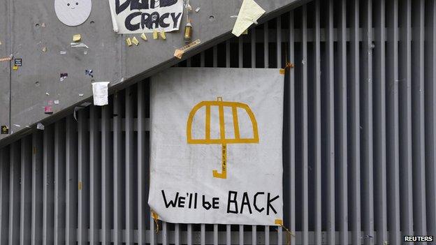 A poster of an umbrella with the words "We'll be back" written underneath is pictured on a wall at the main "Occupy" protest site at Admiralty in Hong Kong on 11 December, 2014