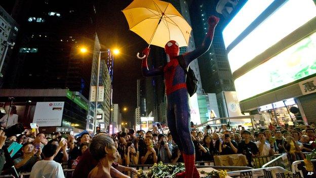 A pro-democracy protester dressed as Spider-man, holding a yellow umbrella, stands on a barricade in the occupied area in the Mong Kok district of Hong Kong, Friday on 24 October, 2014