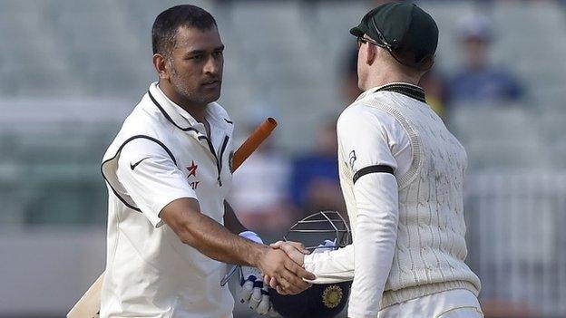 India captain MS Dhoni shakes hands with Australia's Chris Rogers