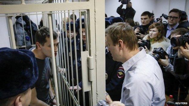 Alexei Navalny (right) speaks to his brother Oleg (left) after the brothers are given difference sentences by a judge in Moscow (30 December 2014)