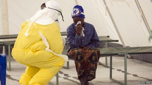 A woman waits to be seen in an Ebola treatment centre.