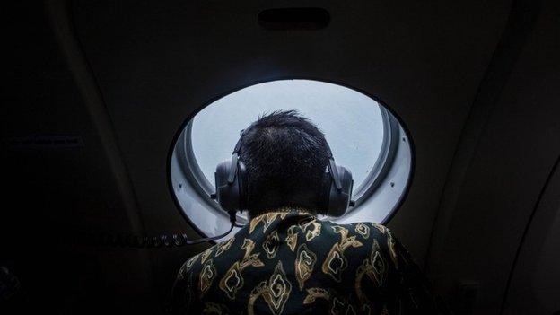 A member of the search team looks out over the waters of the Java Sea, on 30 December 2014