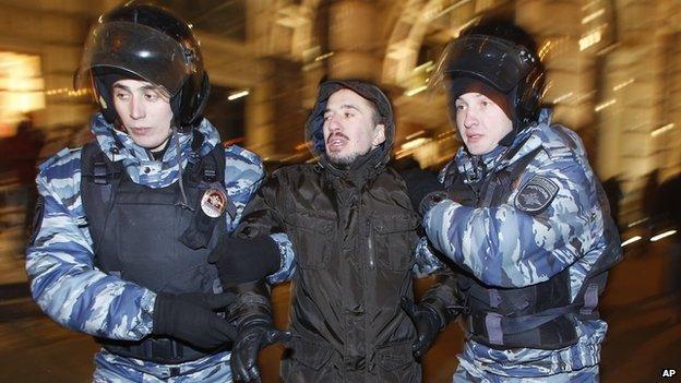 Police officers detain a protester during an unsanctioned protest in Moscow, Russia, Tuesday, Dec. 30, 2014