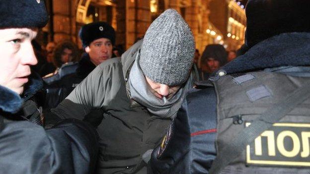 Police officers detain Russian opposition activist and anti-corruption crusader Alexei Navalny, 38, center, on his way to attend a rally in Manezhnaya Square in Moscow, Russia, Tuesday, Dec. 30,