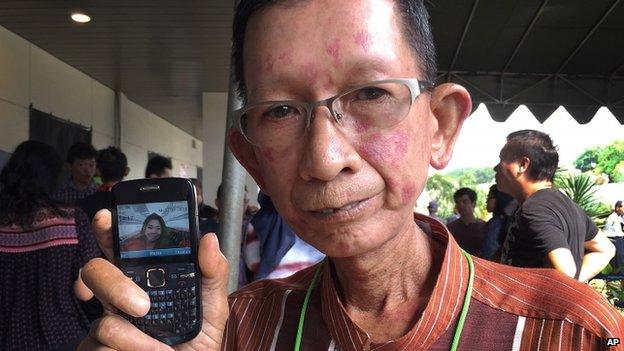 Haidar Fauzie holds up a picture of his daughter Khairunnisa Haidar, a flight attendant on the AirAsia Flight 8501, at Juanda International Airport in Surabaya 31 December