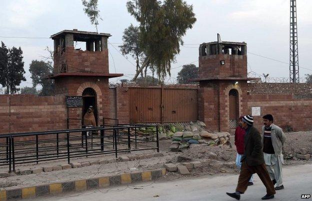 Pakistani pedestrians walk past the central jail in Peshawar on December 31