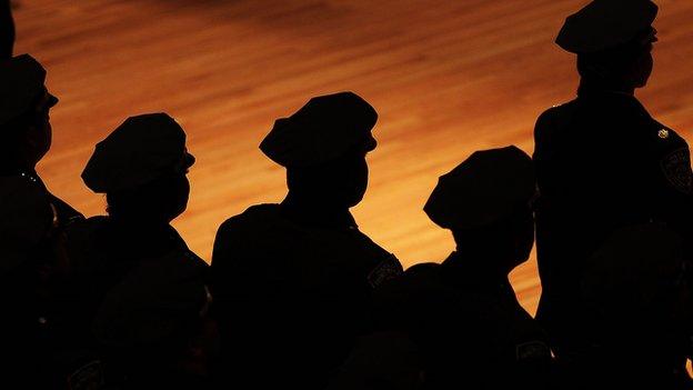 New York police officers stand in silhouette.