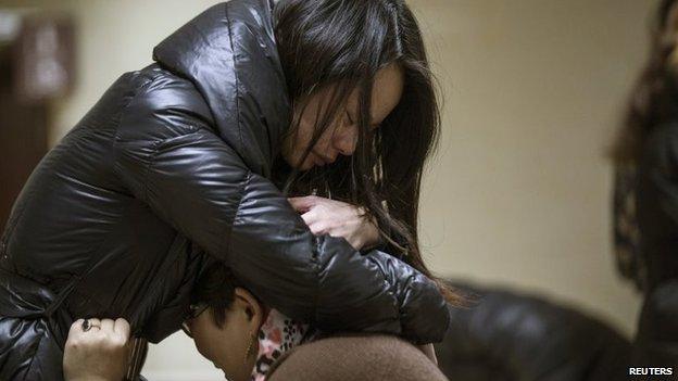 Relatives of a victim hug as they wait at a hospital where injured people of a stampede incident are treated in Shanghai, 1 January 2015