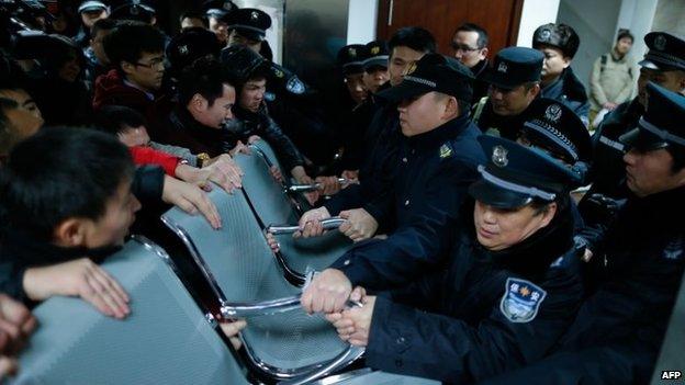 Angry family members clash with security personnel in a hospital where some of the victims of a stampede by new year's revellers were sent in Shanghai, 1 January 2015