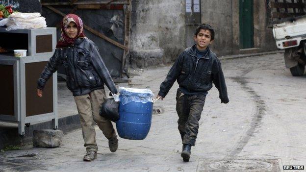 Children carry milk in Aleppo, Syria