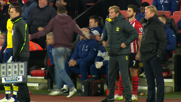 An Arsenal fan confronts Arsene Wenger