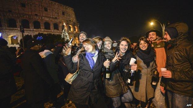 People celebrate in front of the Colosseum in Rome on New Year's Eve