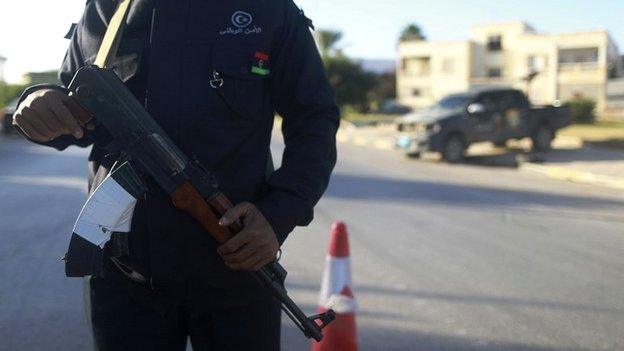 A security officer stands with his weapon on a road leading to a police station in Benghazi - 4 December 2014