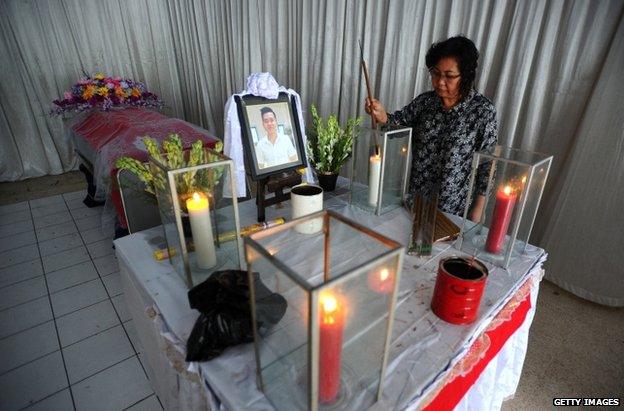 The mother of Hendra Gunawan Syawal, victim of the AirAsia Flight QZ8501 crash, prays near her son's coffin in Surabaya, 3 January