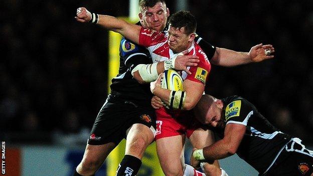 Darren Dawiduik of Gloucester is tackled by Moray Low and Jack Yeandle of Exeter