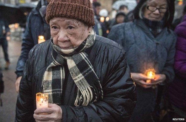 Mourners take part in a candlelight vigil for Wenjian Liu, a day ahead of his funeral, January 3, 2015