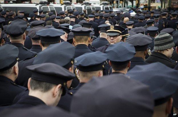 A lone officer faces forward as colleagues turn their backs while Mayor Bill de Blasio speaks during the funeral of New York Police Department Officer Wenjian Liu, 4 January