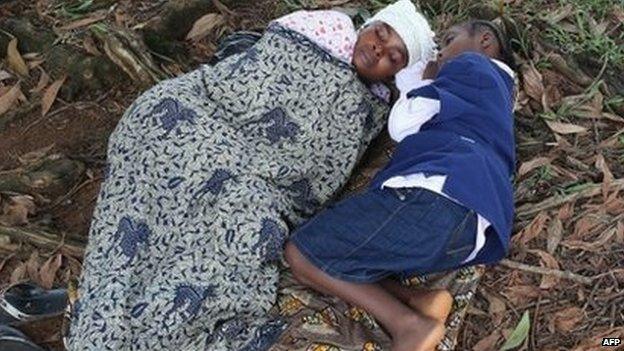 Hanah Siafa lies with her daughter Josephine, 10, while hoping to enter the new Doctors Without Borders (MSF), Ebola treatment centre on 17 August 2014 in Monrovia, Liberia