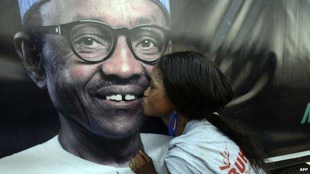 A party member kisses a poster depicting former military ruler and presidential aspirant of the opposition All Progressives Congress (APC) Muhammadu Buhari