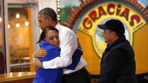 US President Barack Obama hugs the restaurant owner Lilia Yepez as her husband Carlos Yepez looks on during a visit to a Mexican Restaurant in Nashville, Tennessee