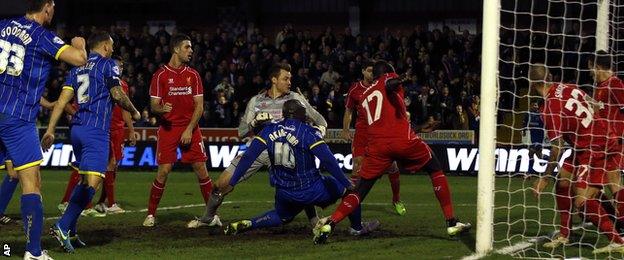 AFC Wimbledon's Adebayo Akinfenwa (centre) scores