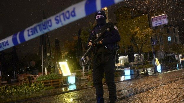 A police officer stands guard along a street after a female suicide bomber was killed on 6 January 2015,