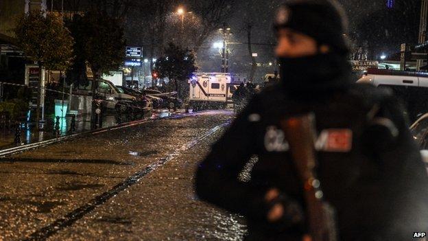 A police officer stands guard along a street leading to a police station where a female suicide bomber was killed on 6 January 2015,