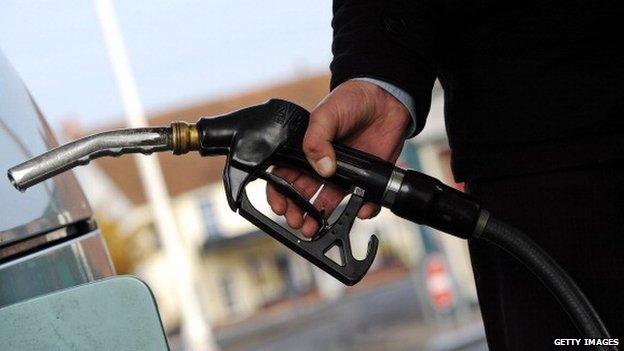 A customer pulls the nozzle of a petrol