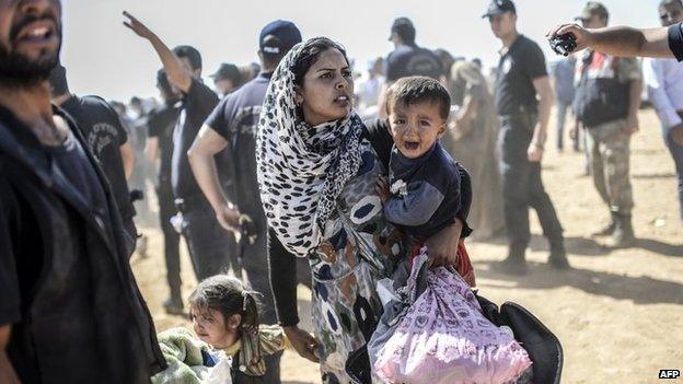 A Syrian Kurdish woman crosses the border between Syria and Turkey at the south-eastern town of Suruc in Sanliurfa province, 23 September 2014