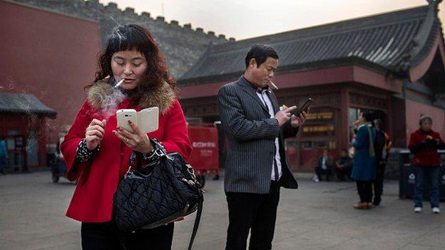 CHINA -NOVEMBER 20: A Chinese man and woman use their smartphones on November 20, 2014 in Beijing, China. China is the largest smartphone market in the world, with some reports estimating there are more than 500 million users in the world's mosrt populated country