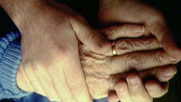 Person holding an elderly person's hand