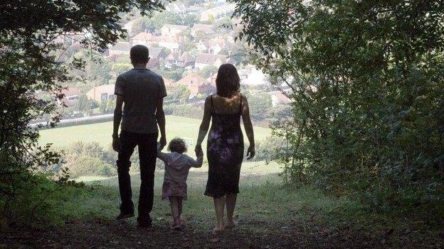 Mother, father and child walking in silhouette