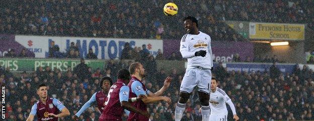 Wilfired Bony of Swansea City heads the ball towards goal against Aston Villa