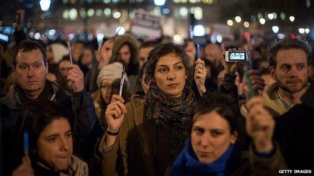 People hold pens aloft during a vigil in Trafalgar Square for victims of the terrorist attack in Paris on 7 January 2015