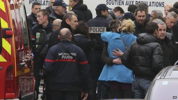 People hug each other outside the French satirical newspaper Charlie Hebdo"s office, in Paris,on 7 January 2015.