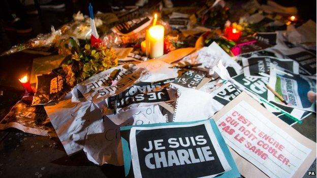 Tributes on the ground as people take part in a vigil in Trafalgar Square, London