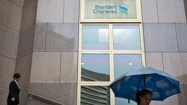 People walk down a stairway from the Standard Chartered bank headquarters building in Hong Kong on August 20, 2014.